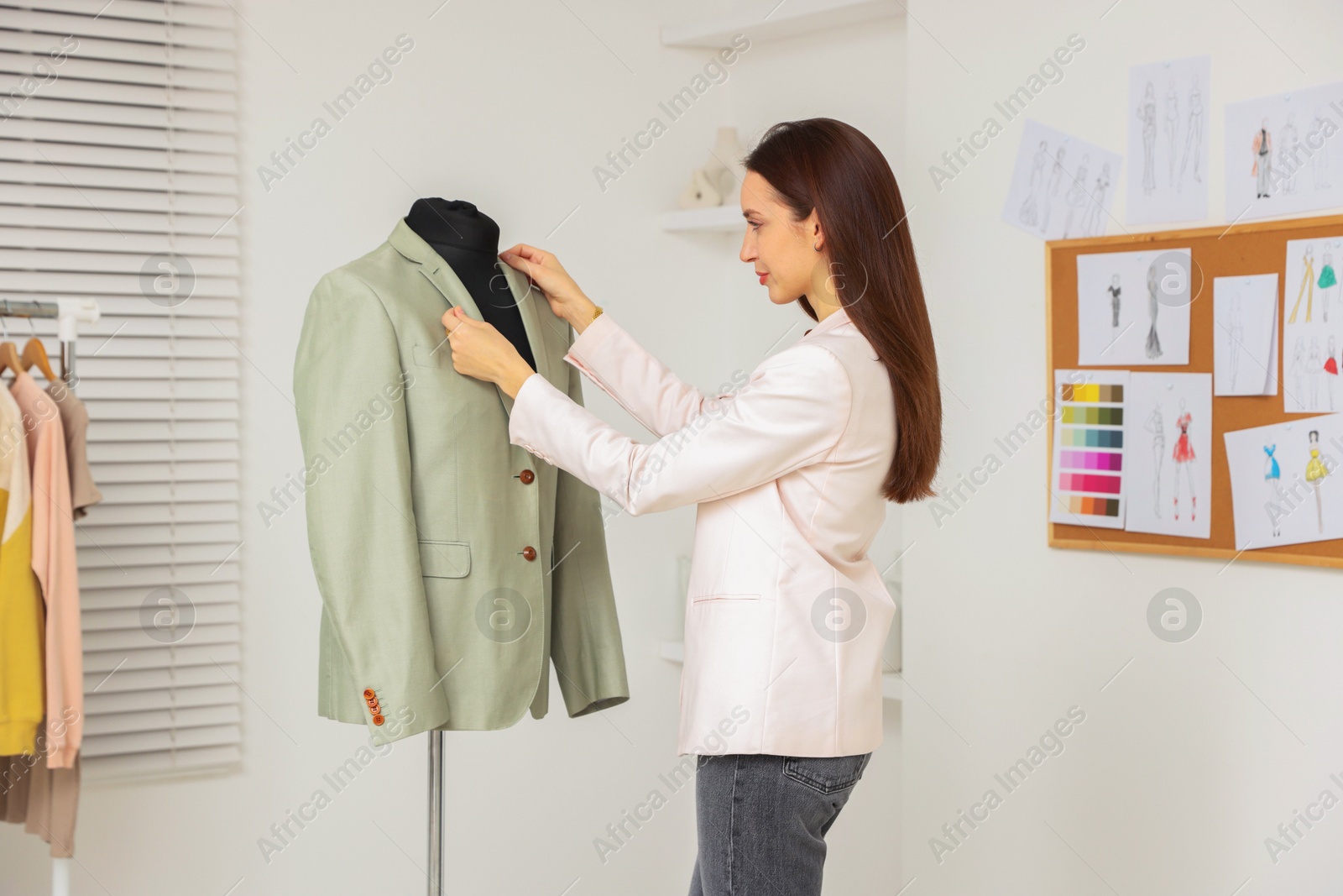 Photo of Fashion designer working with jacket in workshop