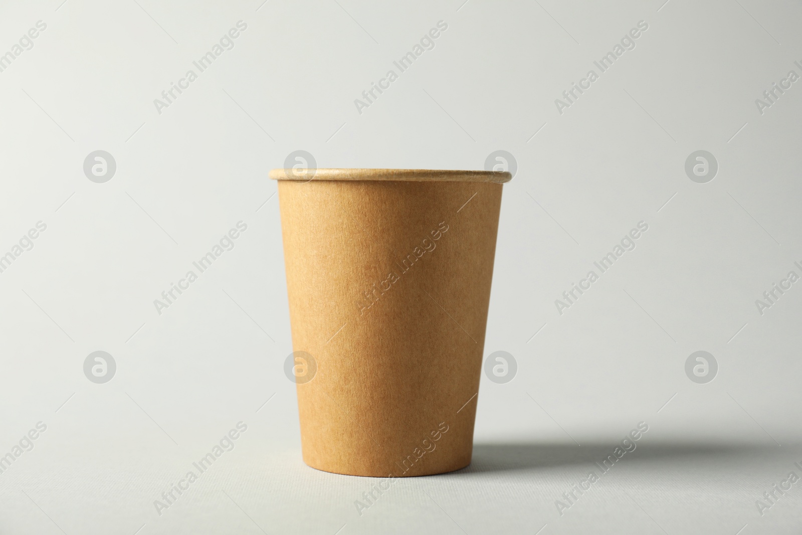 Paper cup on grey background. Mockup for design Photo of Paper cup on grey background. Mockup for design