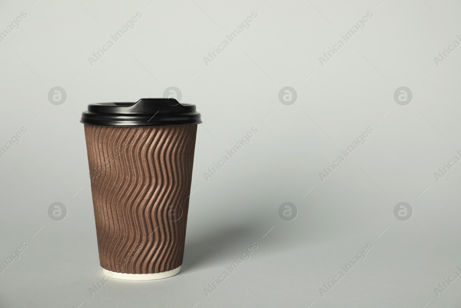 Paper cup with lid on grey background. Mockup for design Photo of Paper cup with lid on grey background. Mockup for design
