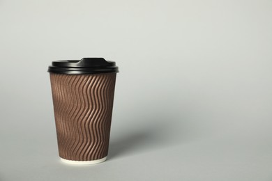 Photo of Paper cup with lid on grey background. Mockup for design