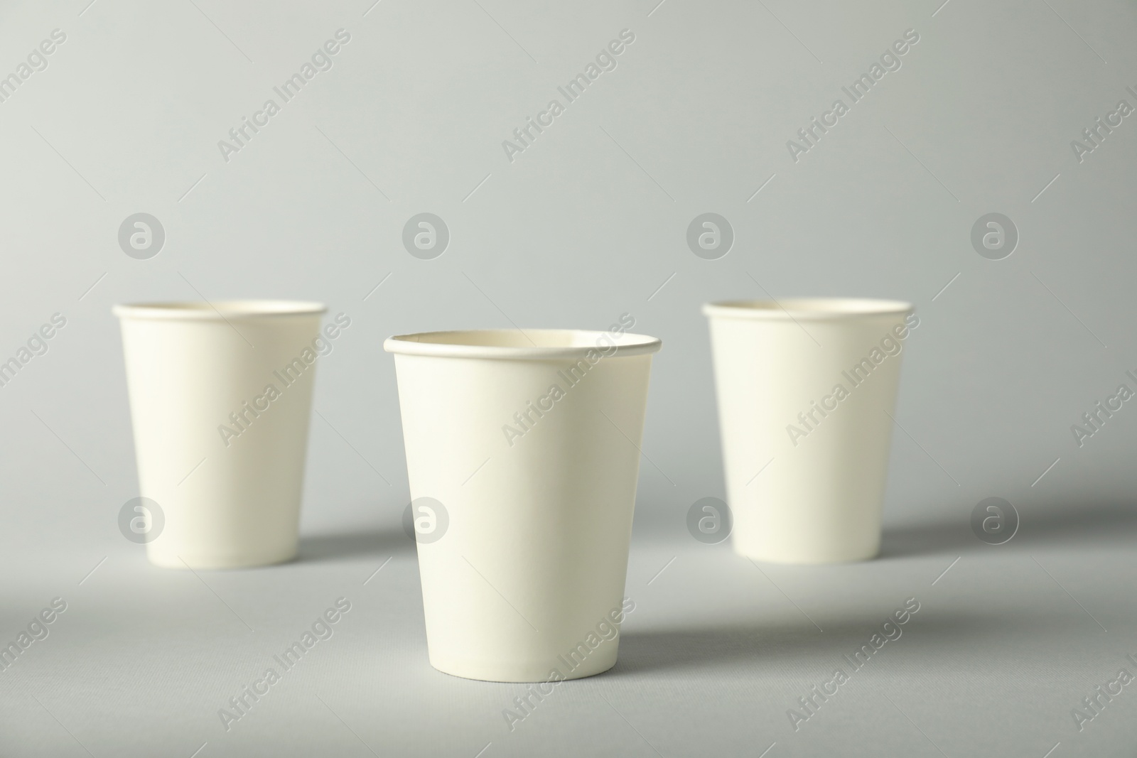 Paper cups on grey background. Mockup for design Photo of Paper cups on grey background. Mockup for design