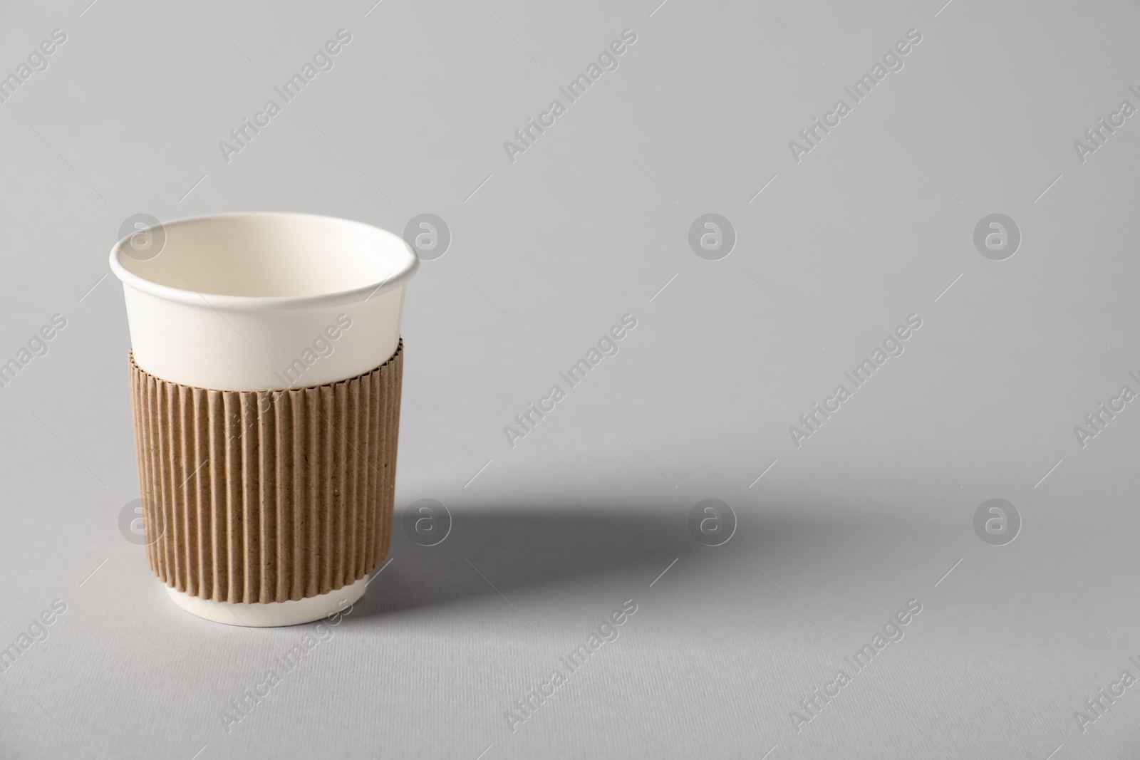 Paper cup on grey background. Mockup for design Photo of Paper cup on grey background. Mockup for design