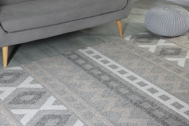 Photo of Stylish soft rug with pattern on floor in living room