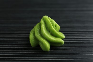 Photo of Hot wasabi paste on black textured table, closeup