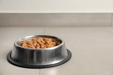 Photo of Wet pet food in feeding bowl on floor, space for text