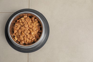 Photo of Wet pet food in feeding bowl on floor, top view. Space for text