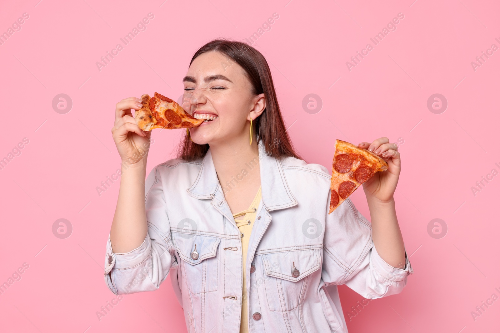 Photo of Beautiful woman with delicious pizza on pink background