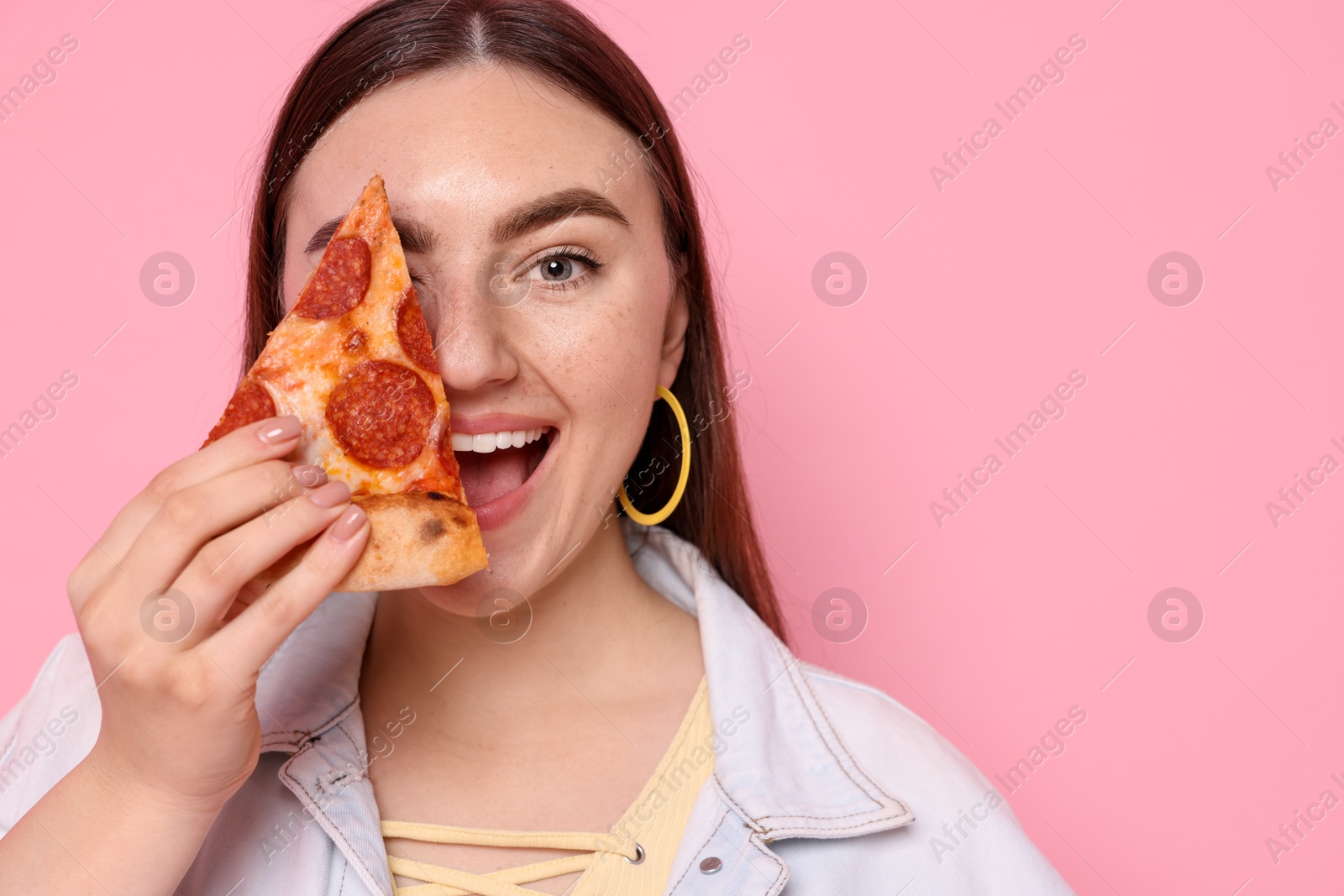 Photo of Beautiful woman with delicious pizza on pink background, closeup. Space for text