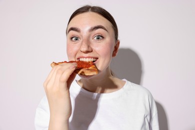 Photo of Beautiful woman eating pizza on white background