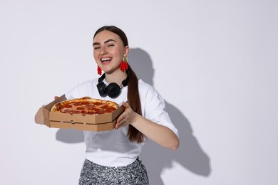 Beautiful woman with delicious pizza on white background, space for text