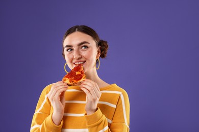 Beautiful woman eating pizza on violet background, space for text