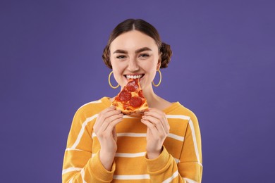 Photo of Beautiful woman eating pizza on violet background