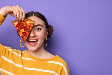 Photo of Beautiful woman with piece of delicious pizza on violet background, space for text