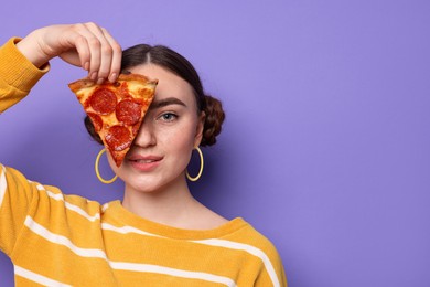 Beautiful woman with piece of delicious pizza on violet background, space for text