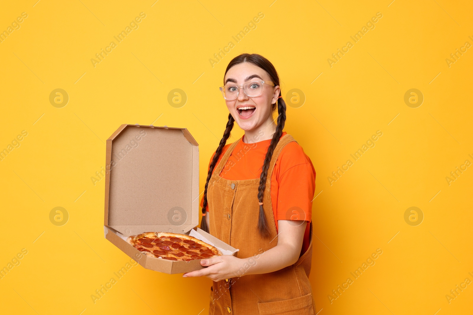 Photo of Beautiful woman with delicious pizza on orange background