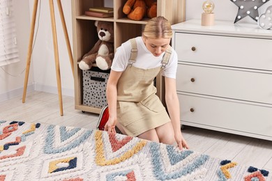 Female decorator placing carpet in child's room