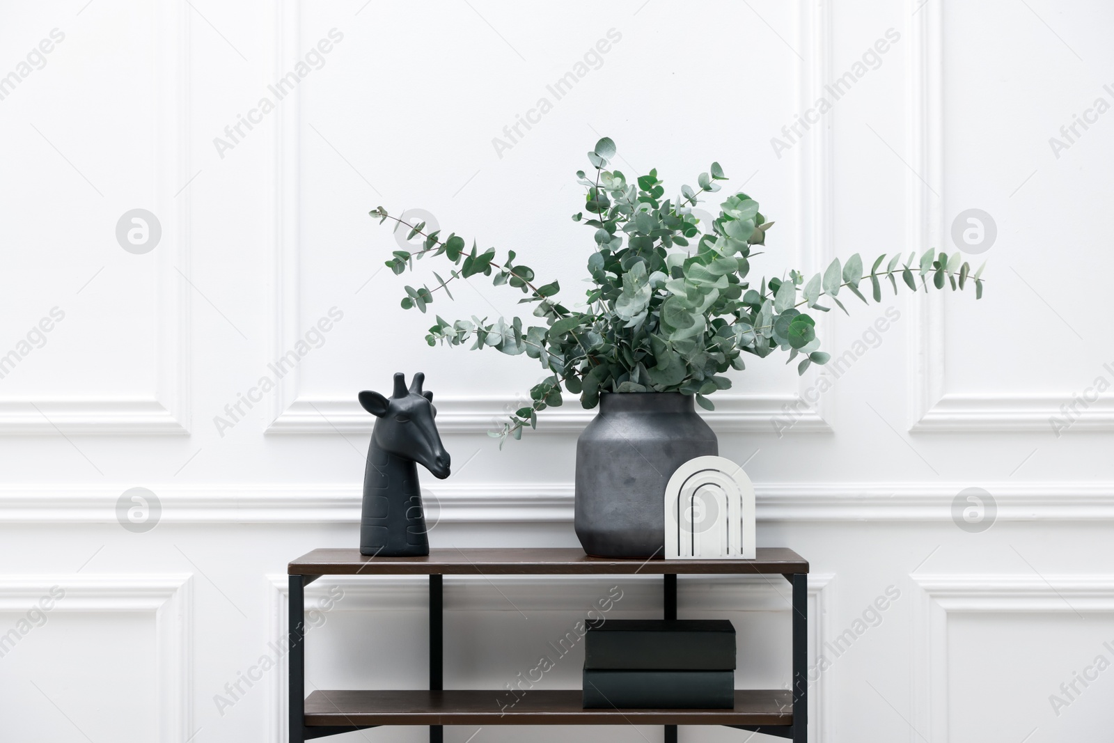 Photo of Console table with decor near white wall in room. Interior design