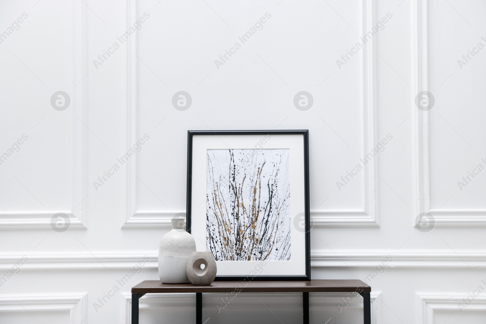 Photo of Console table with decor near white wall in room. Interior design