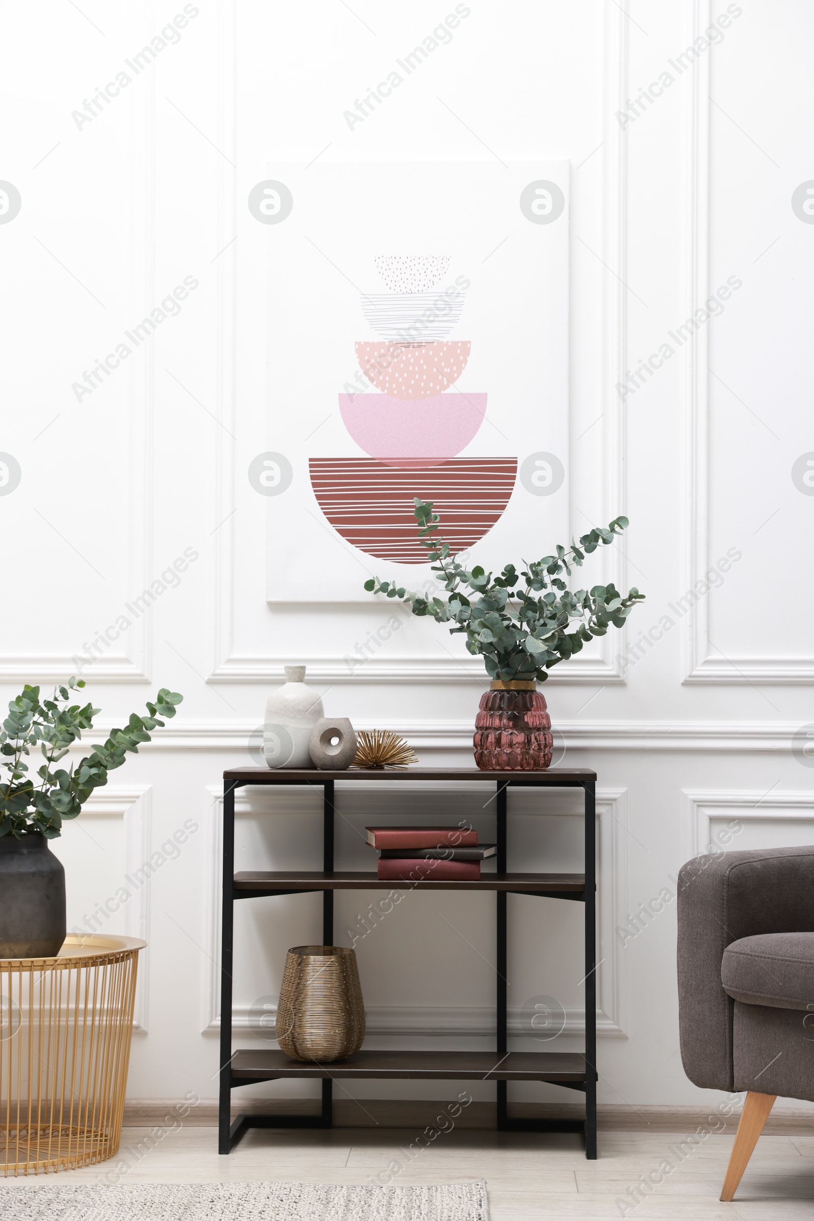 Photo of Console table with decor near white wall in room. Interior design