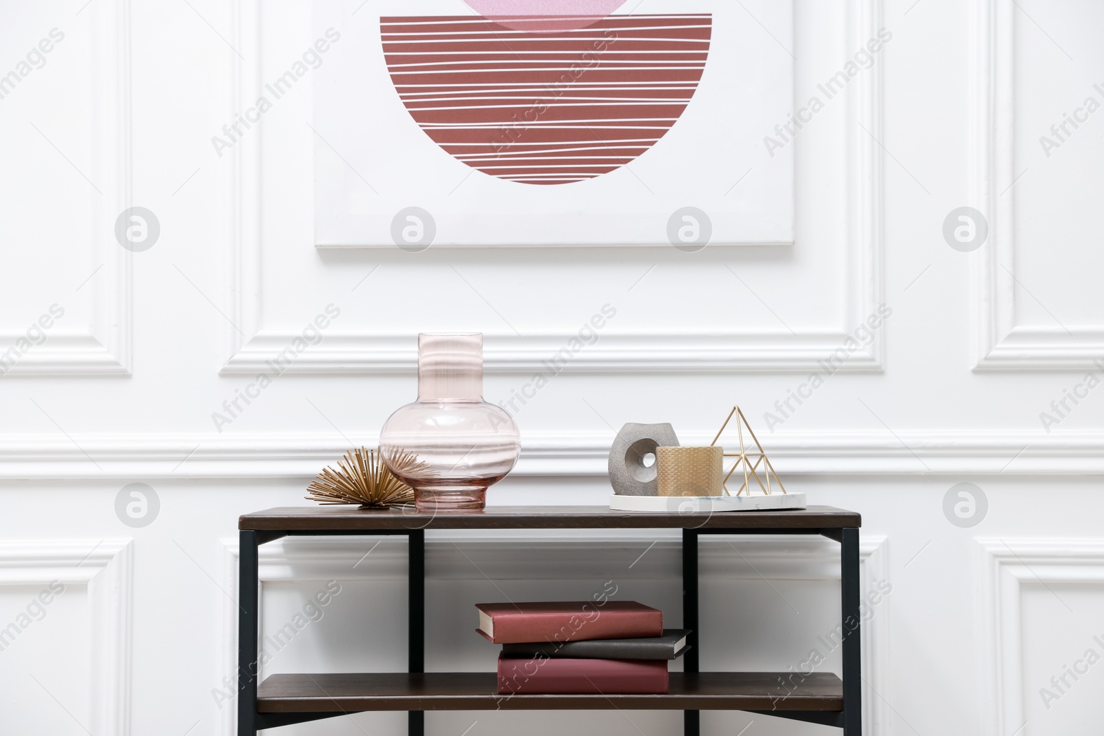 Photo of Console table with decor near white wall in room. Interior design