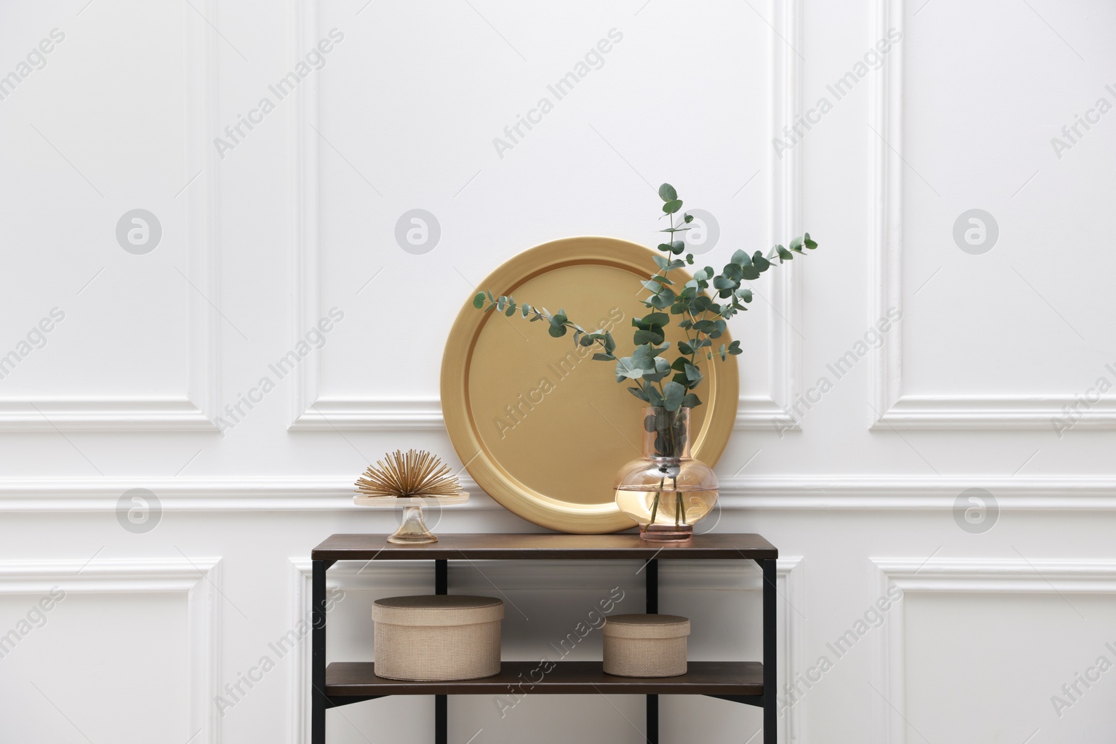 Photo of Console table with decor near white wall in room. Interior design