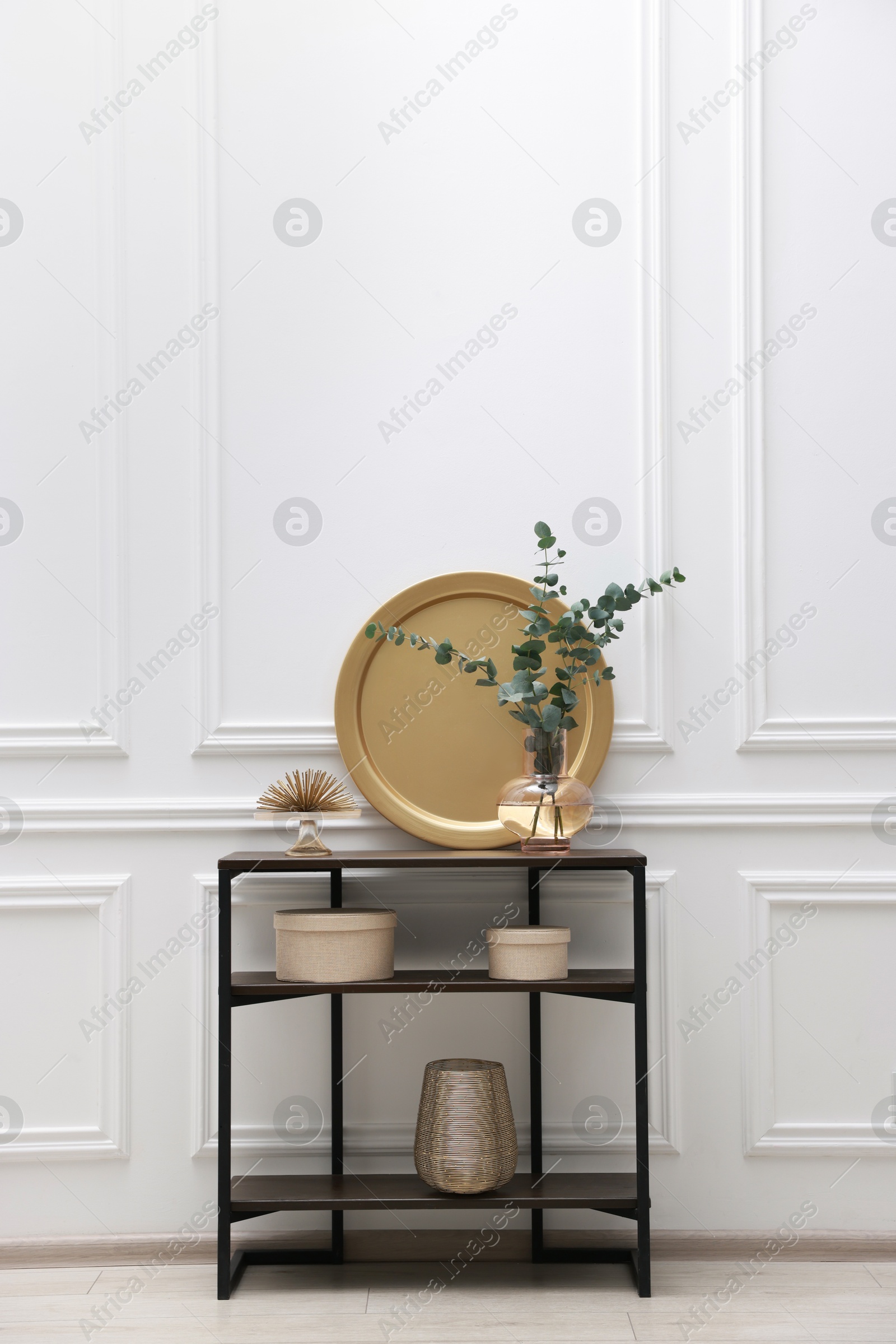 Photo of Console table with decor near white wall in room. Interior design