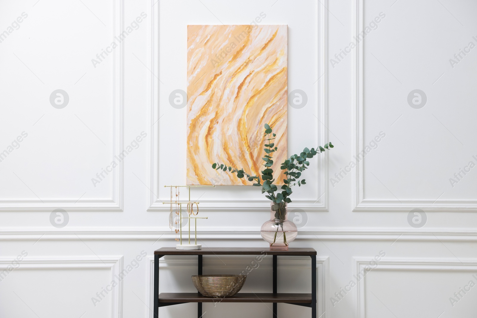 Photo of Console table with decor near white wall in room. Interior design