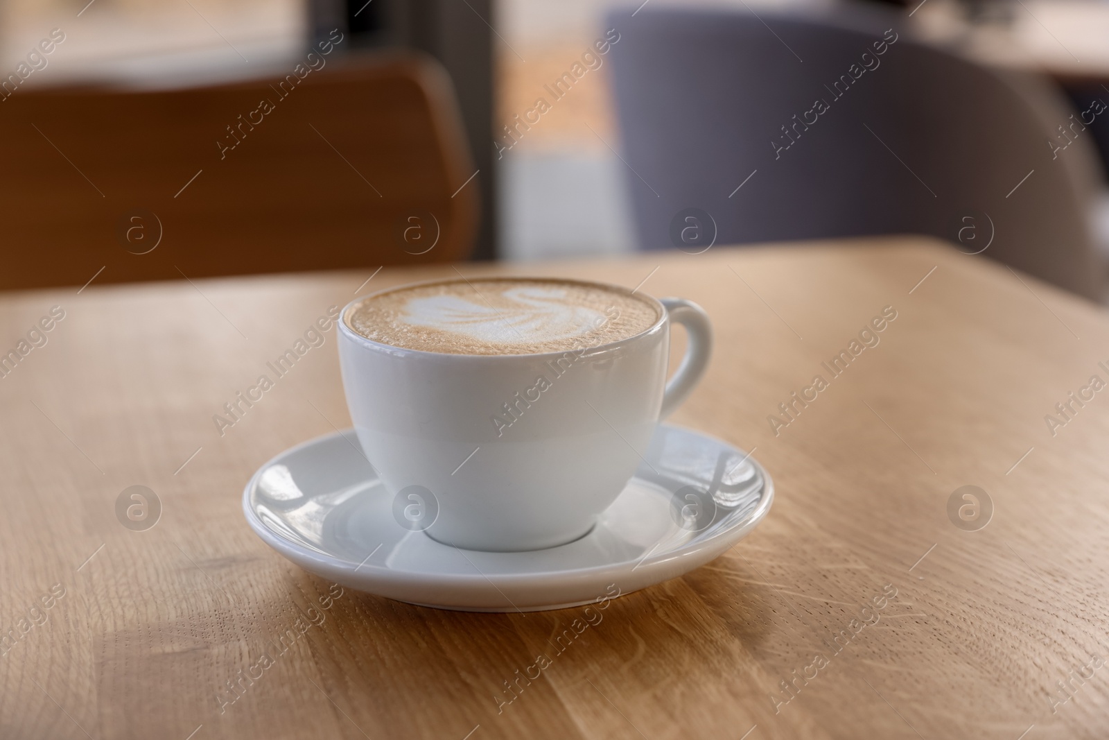 Photo of Cup of aromatic coffee on wooden table in cafe, closeup