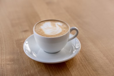 Photo of Cup of aromatic coffee on wooden table in cafe, closeup