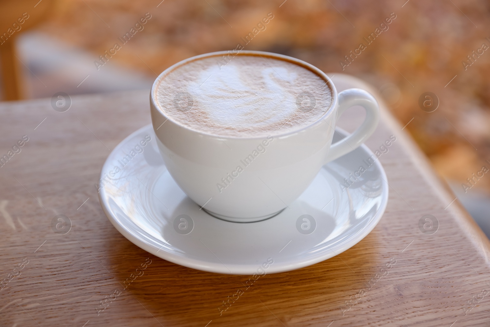 Photo of Cup of aromatic coffee on wooden table in cafe, closeup