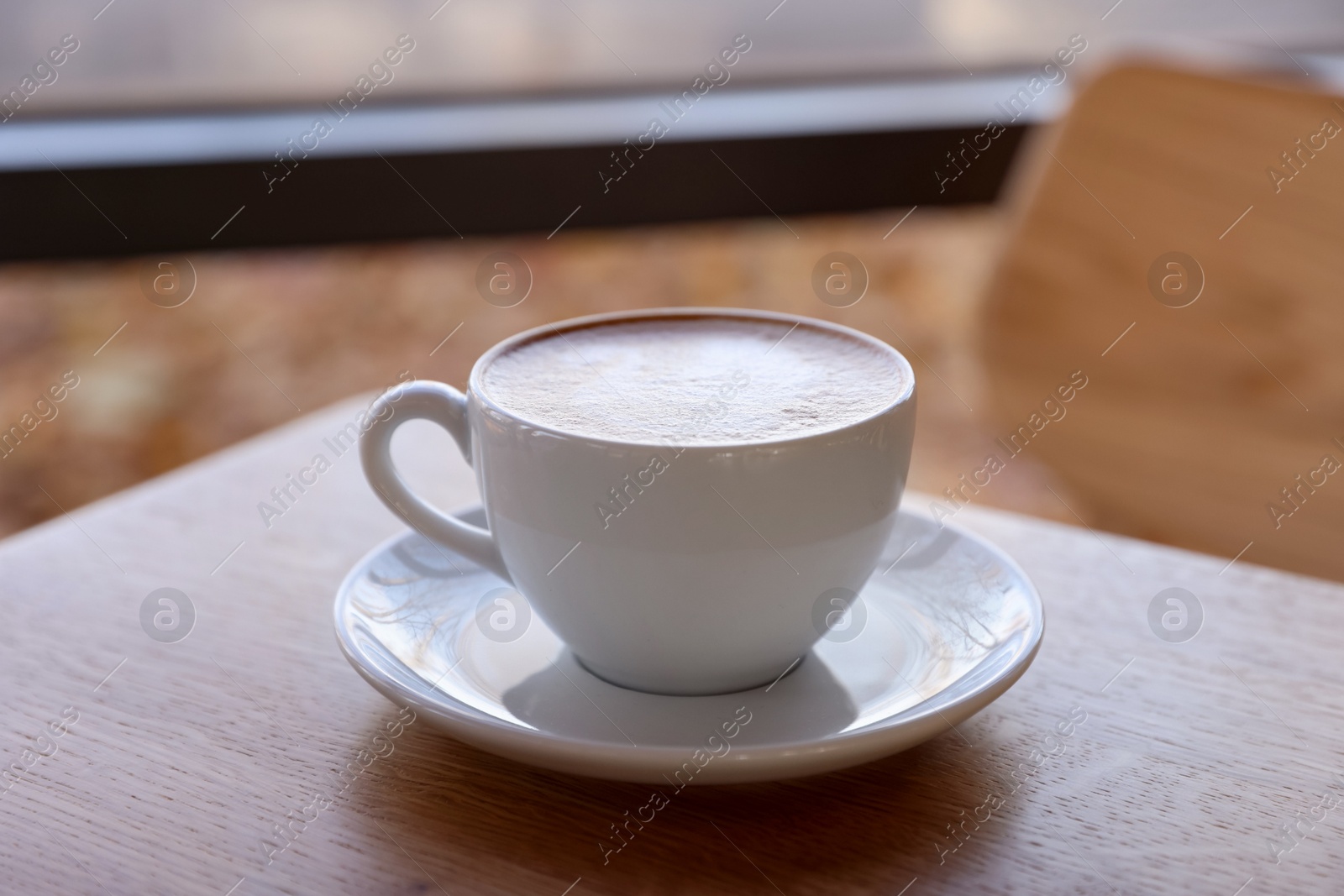 Photo of Cup of aromatic coffee on wooden table in cafe, closeup