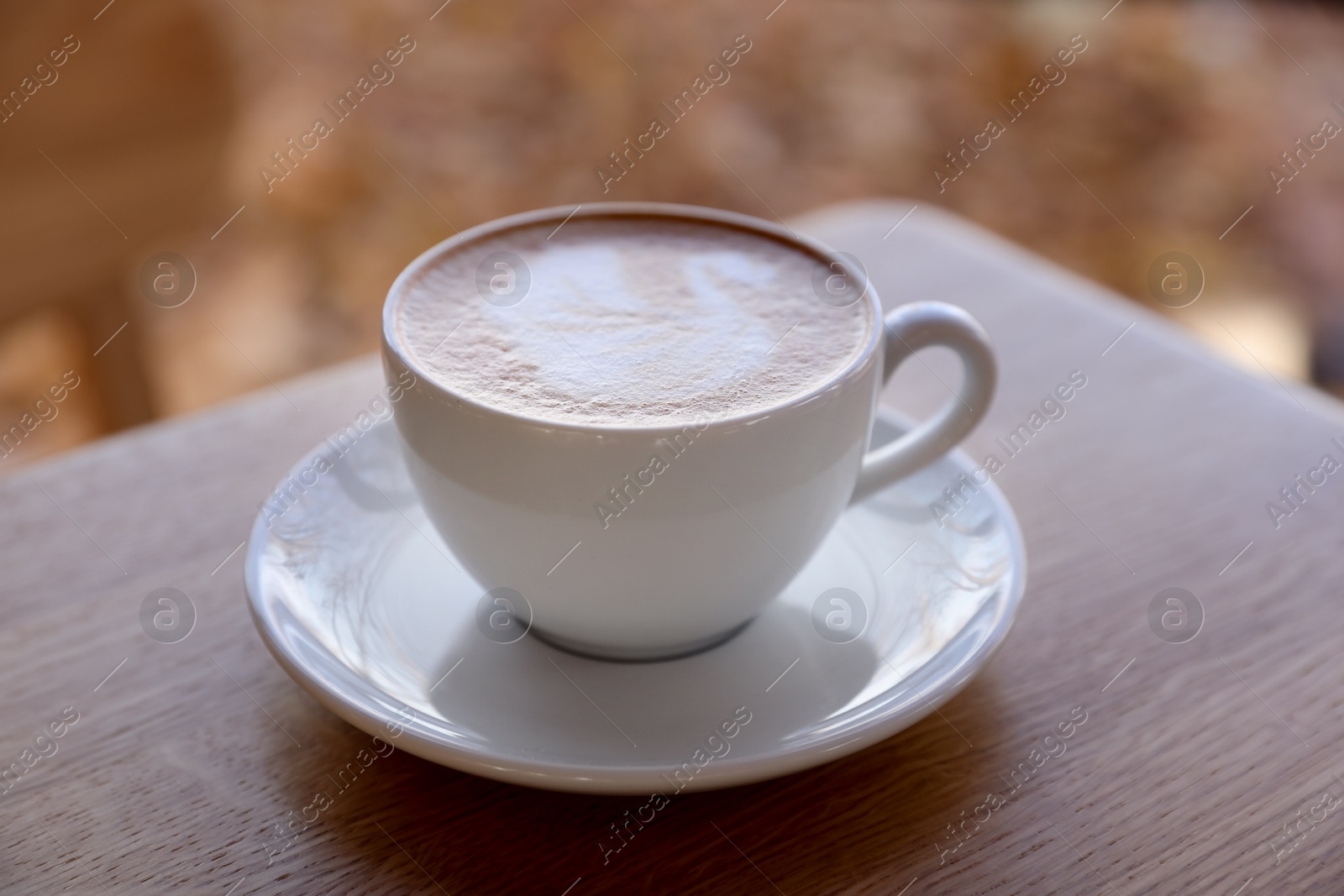 Photo of Cup of aromatic coffee on wooden table in cafe, closeup