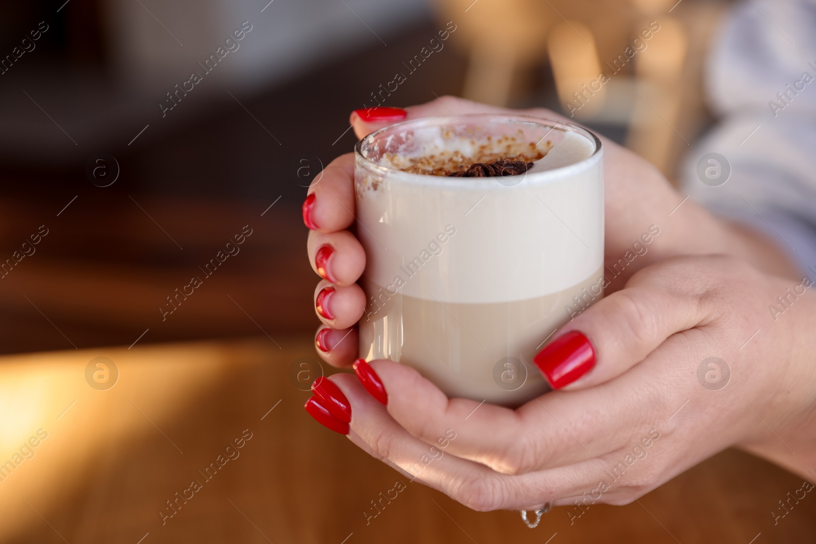 Photo of Woman with glass of aromatic coffee in cafe, closeup. Space for text