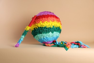 Photo of Colorful pinata and stick on beige background