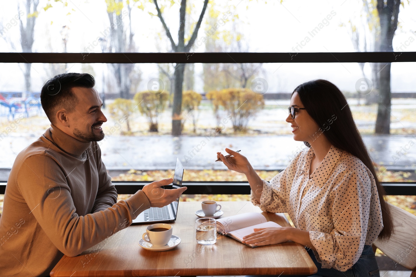 Photo of Man and woman working together in cafe