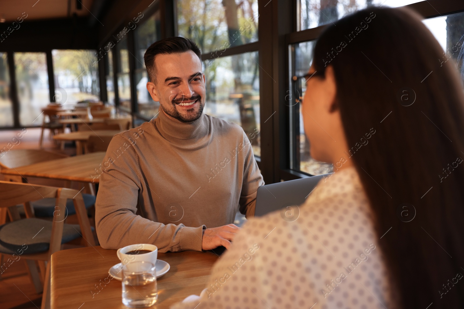 Photo of Colleagues working together at table in cafe