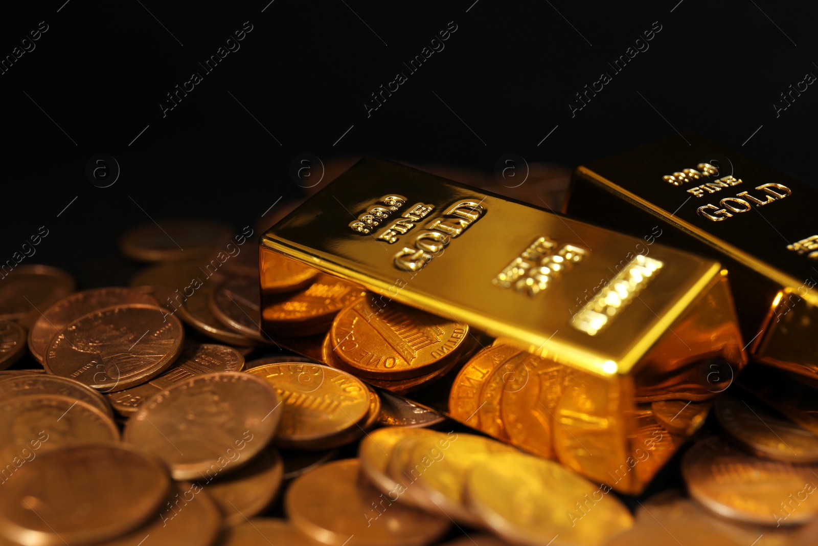 Photo of Gold bars and coins on black background, closeup