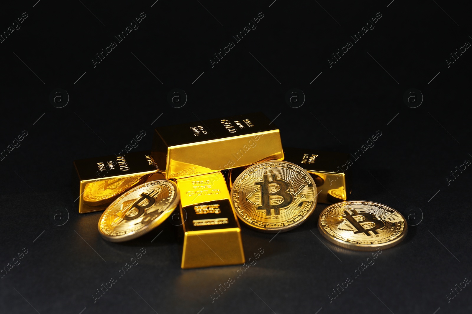 Photo of Gold bars and coins on black table, closeup