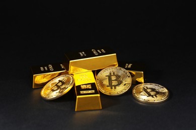 Photo of Gold bars and coins on black table, closeup