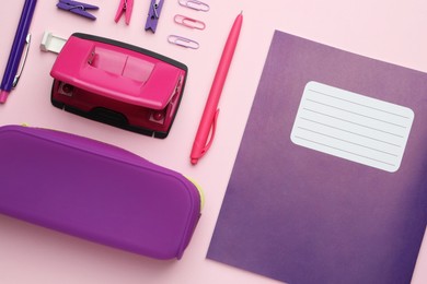 Photo of Copybook and other school stationery on pink background, flat lay