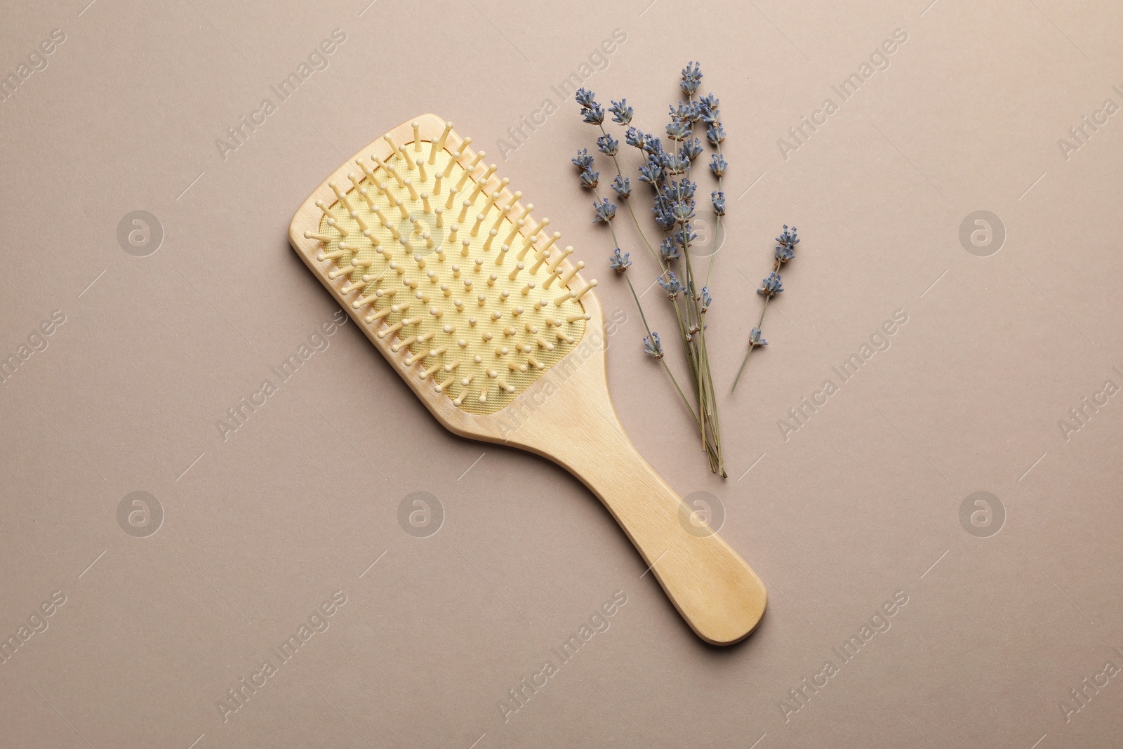 Photo of Wooden hair brush and lavender flowers on color background, top view