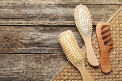 Photo of Hair brushes and comb on wooden background, flat lay. Space for text