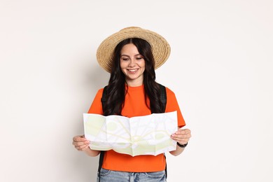 Young tourist in hat with map on white background