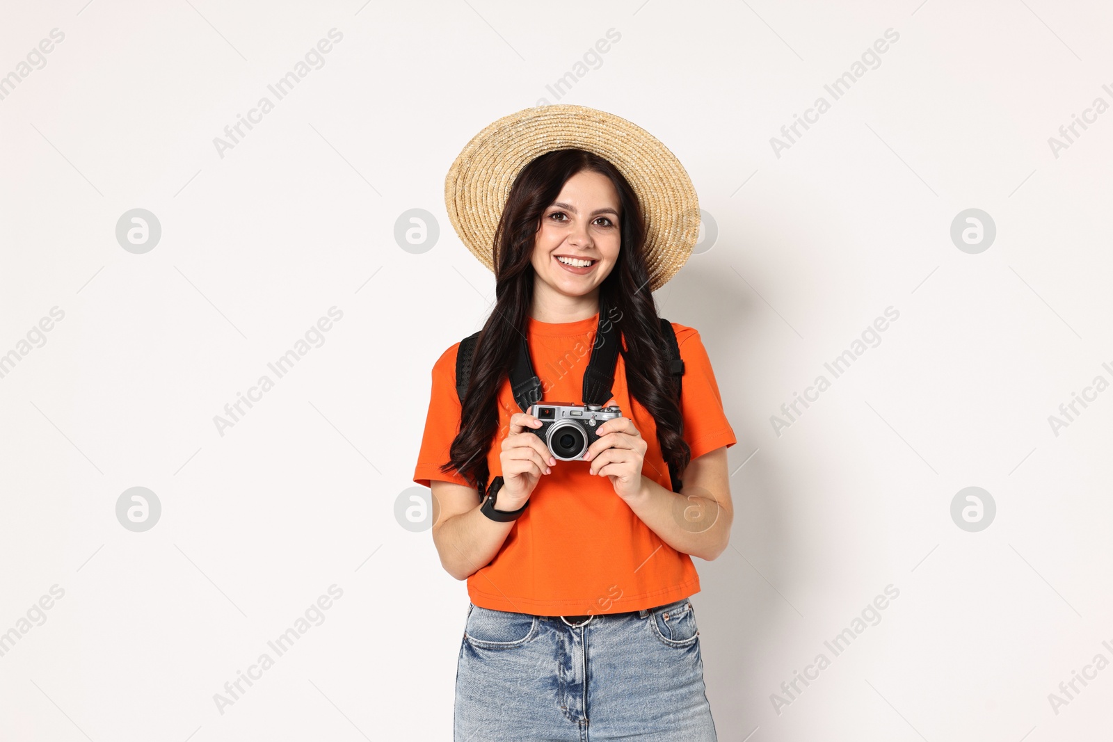 Photo of Young tourist in hat with camera and backpack on white background