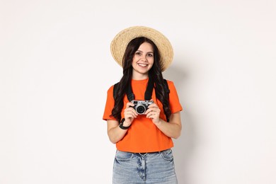 Photo of Young tourist in hat with camera and backpack on white background