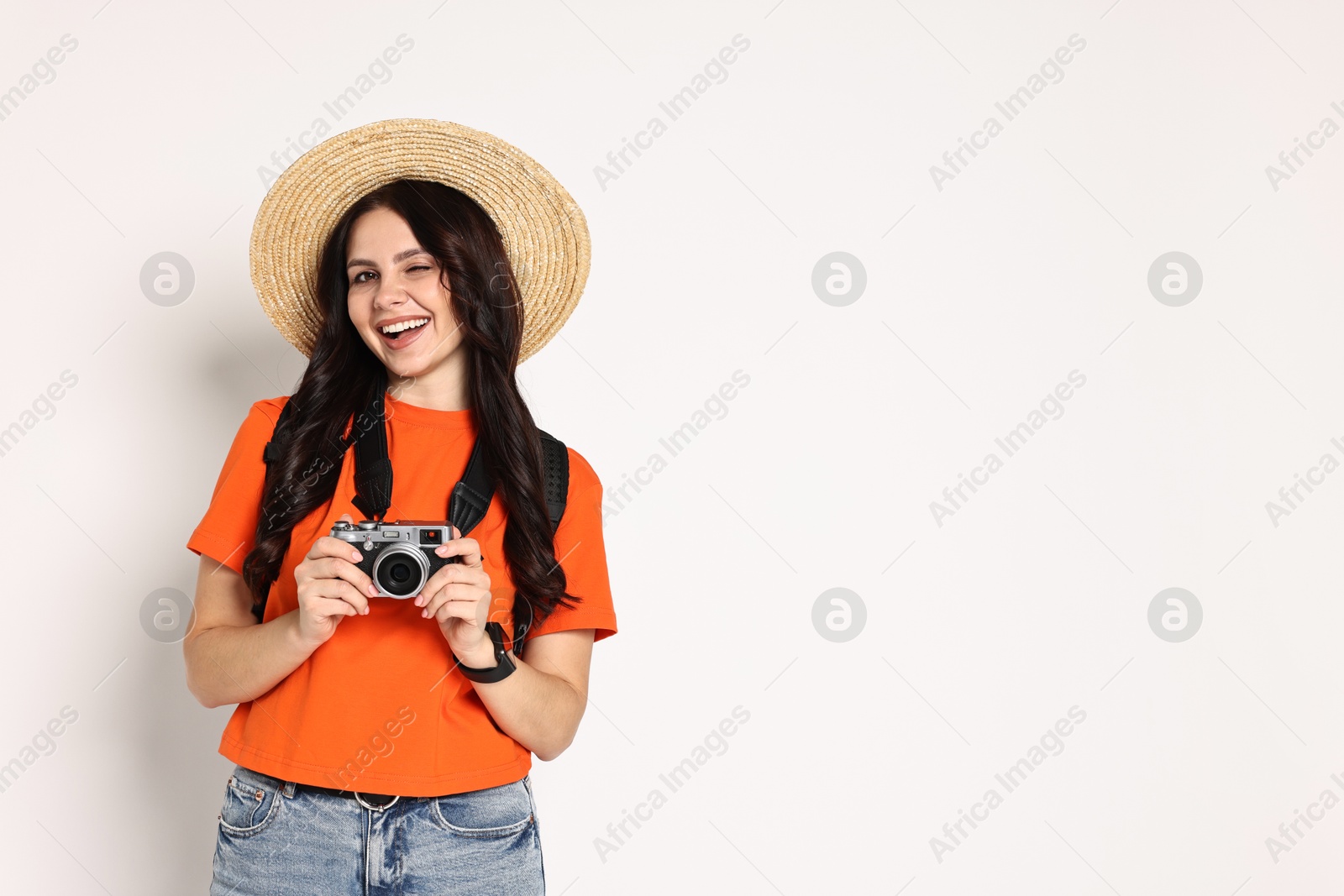 Photo of Young tourist in hat with camera and backpack on white background, space for text