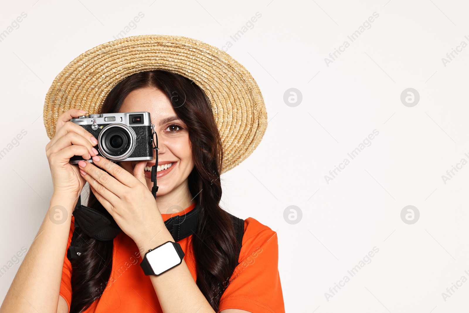 Photo of Young tourist in hat with camera and backpack on white background