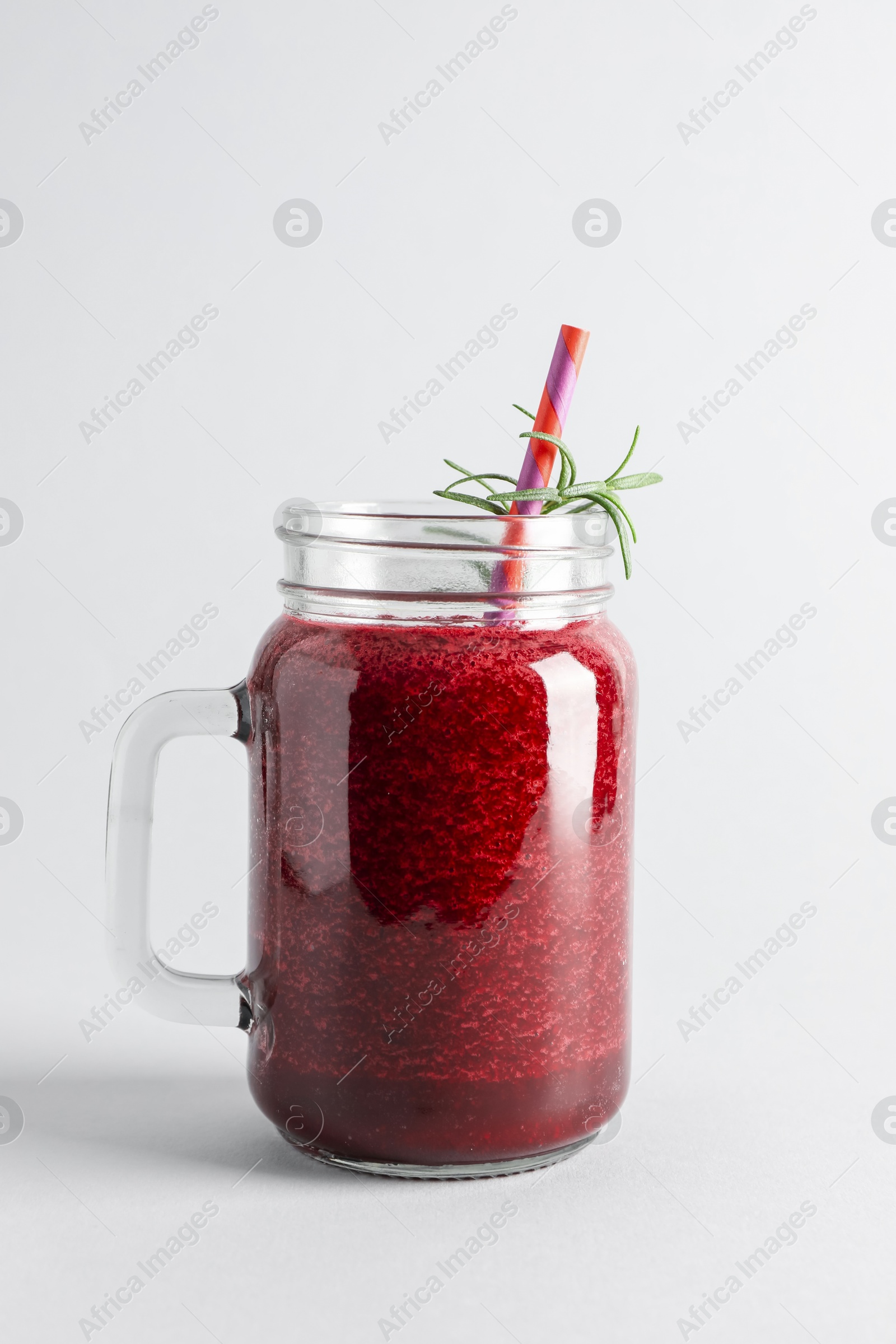 Photo of Fresh beetroot smoothie in mason jar on light background, closeup