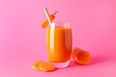 Photo of Fresh carrot smoothie in glass and cut vegetable on pink background, closeup