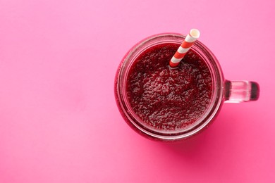 Photo of Fresh beetroot smoothie in mason jar on pink background, top view. Space for text